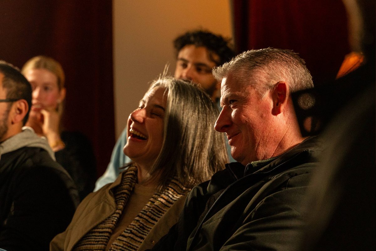 A couple laughing together in the audience at one of Sam King's shows